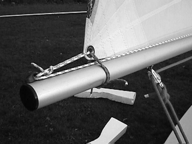 Wrap the sail sleeve around the mast (with the free end of the halyard inside) above the gooseneck and engage about three inches of zipper to hold it in place.