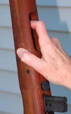 CLEARING AN M1 CARBINE: 1) Grasp the operating rod handle and pull to the rear, 2) while