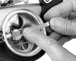 11) To bend the lever down, place the disk end of the KMDSI 1/4 wrench onto the flat area of the adjustment tube within the regulator, sliding the disk as far as possible under the lever.