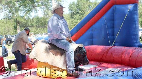 Levy County Commission Vice Chairman Mike Joyner rides a mechanical bull after County Judge Tim