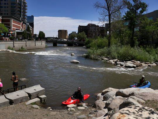 Paddlers Ben Spillman, right, and Noah Fraser take a break while paddling the Truckee River Whitewater Park in downtown Reno on May 13, 2016.