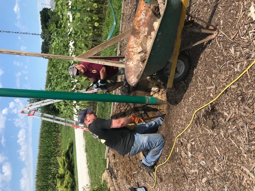 Matthew King, Michael Kreuger, and Kevin Doute pull up old concrete and pour new to level a listing swing at the Farmstead.
