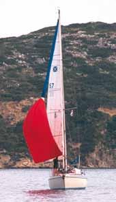 Put the boat well off the wind, attach the tack strop and hoist the contained chute in the lee of the mainsail With the halyard and tack strop secured, partially unsheathe