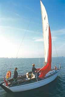 Trip the tack of the chute and let it flag downwind in the lee of the mainsail Walk aft and