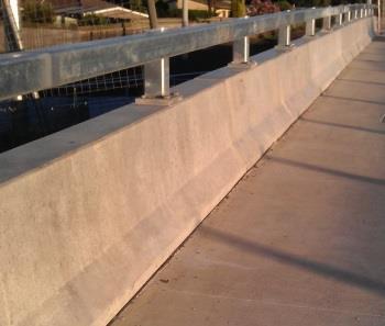 It is highly recommended to install a rigid type of roadside barrier on a bridge section, and the height of