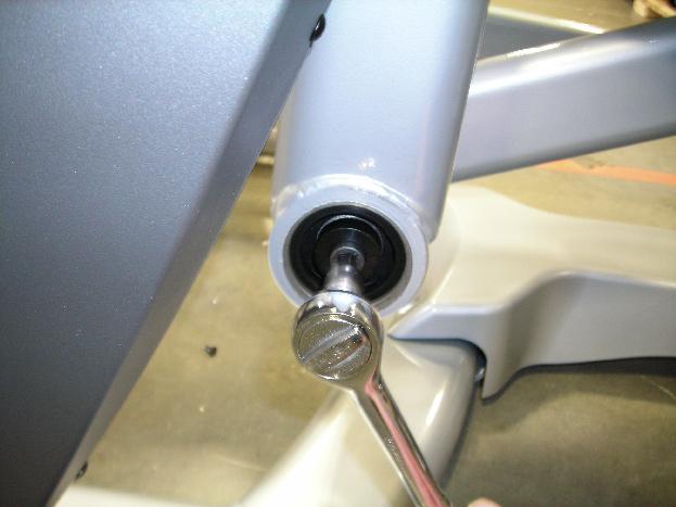 5) Holding onto the swing arm, push / pull the pivot shaft out of the bearing housing (Figures F and G).