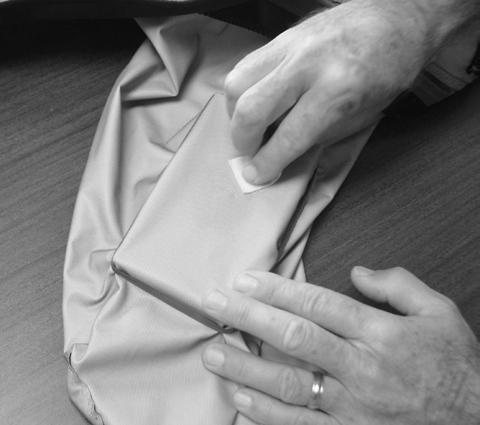 Step 1: Turn your garment inside out. Make sure the suit is clean and dry. Place a flat hard object inside the suit directly under the hole.