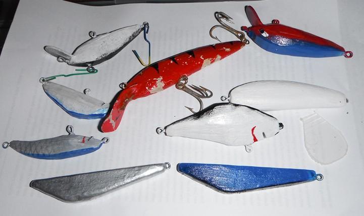 Clockwise from centre: Balsa lure with tiger stripes, red and blue lure with panted eyes, balsa minnow with undercoat, gills painted on and clear bib ready for gluing, blue and silver paint