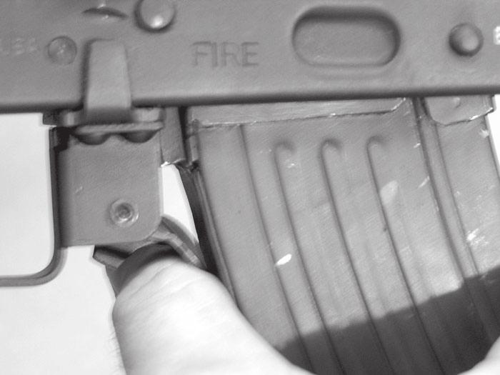 2. Fig 12: Remove the magazine by pushing the magazine release lever forward until it touches the body of the magazine, while keeping the release lever in the forward position swing the magazine