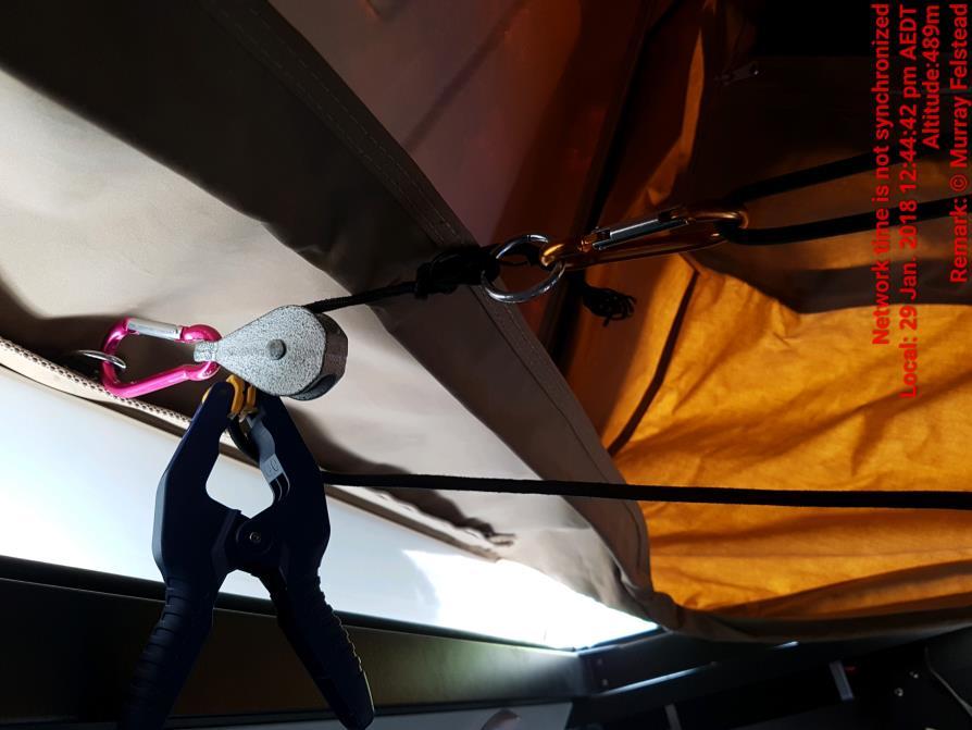 location of the pulley, and in the process, pulling the centre bottom of the tent up. During this process, I am sitting down on the seat, just under the rings near the hinge.
