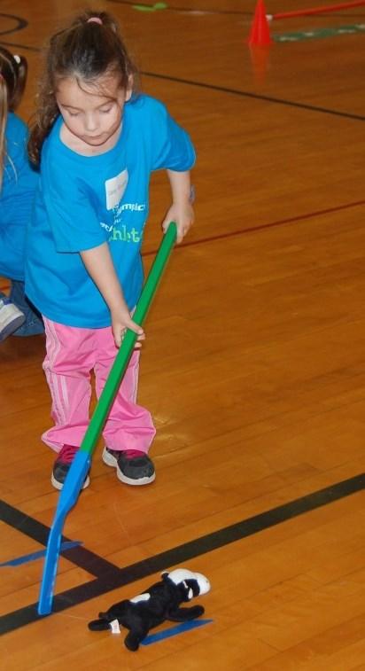 Have the child hold onto a dowel, hockey stick, golf club, etc., with two hands and encourage him/her to strike the ball with the club or stick.