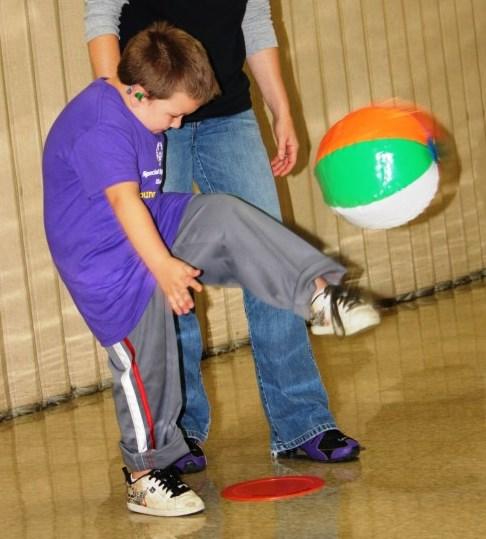 punting beach ball, slow motion ball, junior size basketball, playground ball Encourage the child to practice one-legged standing balance with the leg forward and the arms out to