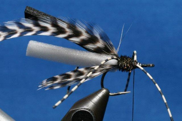 In a like manner, tie in the front leg set ¼-inch back from the hook eye. Take the thread back to the point directly above the hook barb. 5. Tie in the peacock herl and saddle feather.