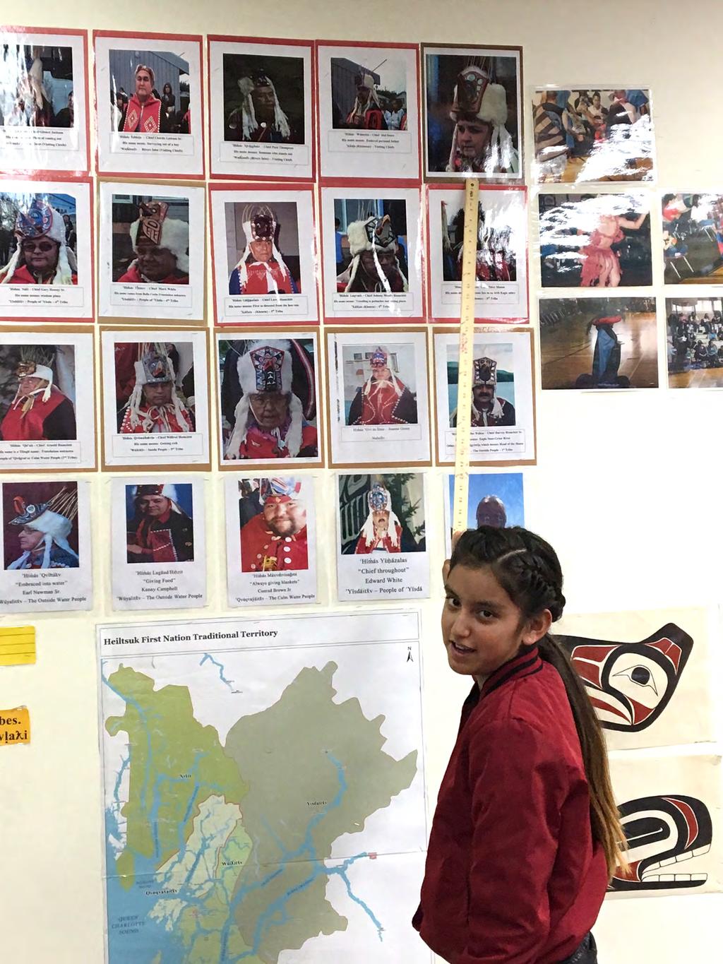 A grade 4/5 student pointing to a photo of a Heiltsuk yím as