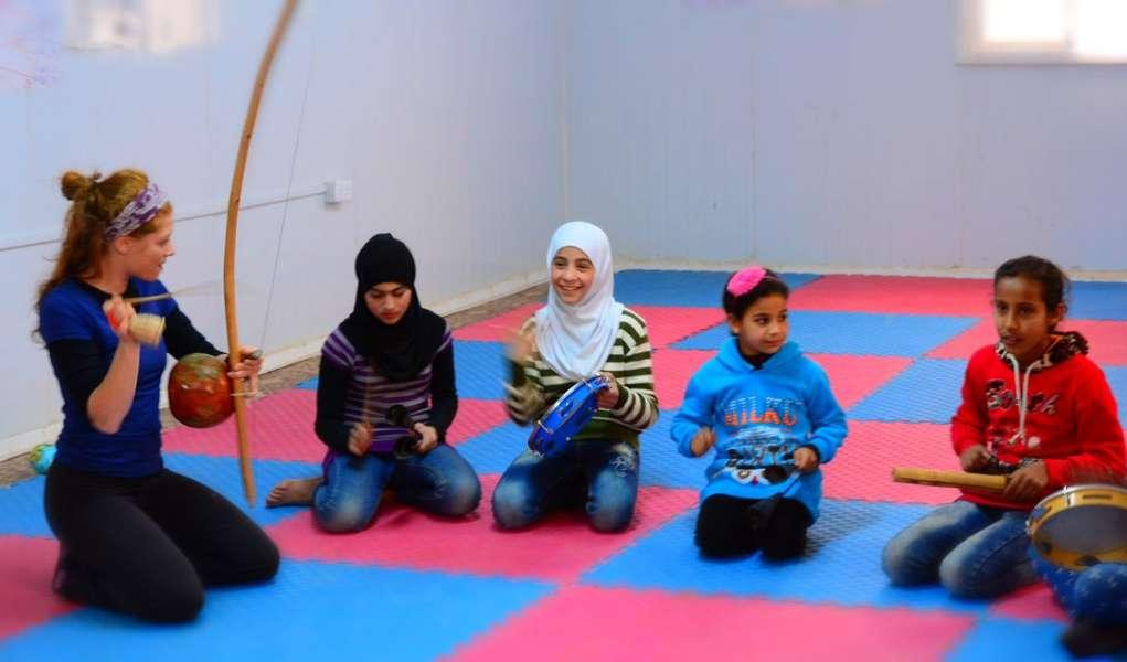 Capoeira al-shababi Trainer and girls practicing traditional Capoeira instruments in Za atari refugee camp, Peace Oasis, January 2018.