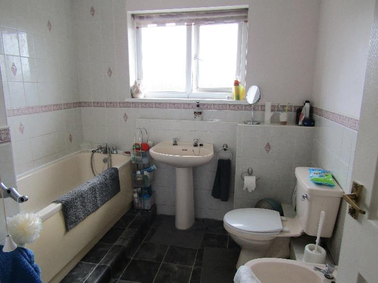 Bathroom: raised panel bath with mixer taps and shower attachment, pedestal hand basin, wc, bidet, opaque window, radiator.