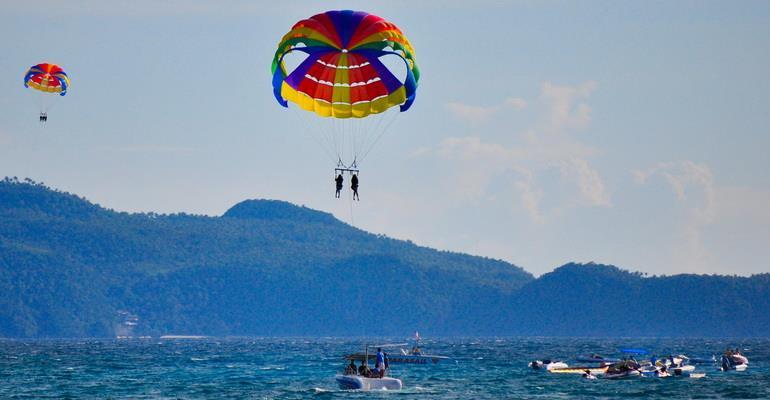 Parasailing Imagine being whisked into the sky while strapped in a seat covered by a colorful parachute!