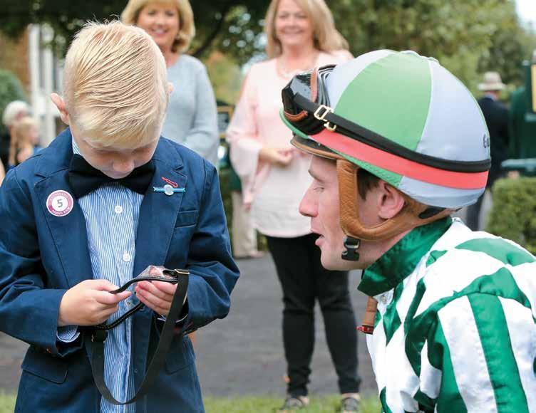 Jack Wells examines a pair of goggles as jockey Declan Cannon explains his racing equipment. PHOTOS BY Z learn about what we do, and then we turn around and introduce them to racing.