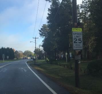 with three high-visibility signs: a Share The Road sign, a School Ahead