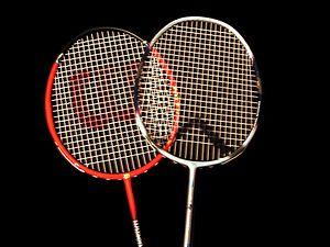 Badminton Badminton is a recreational sport played by either two opposing players (singles) or two opposing pairs (doubles), that take positions on opposite halves of a rectangular court divided by a