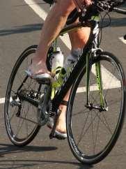 I know the triathletes who are putting their feet in the shoes while riding are doing so as they move forward while the person who puts the shoes on in transition are stationary.