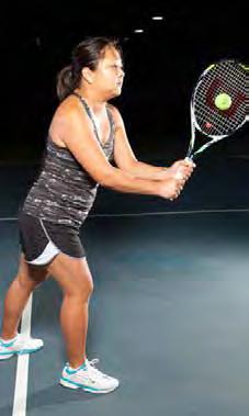 The left hand is holding the racket slightly tighter than the right hand. Feet are a shoulder width apart and the body is in equal balance.