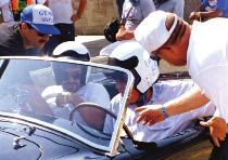 He changed cars like the endurance driver he used to be and his passenger jumped in (so happy to be in a car Carroll Shelby was driving it wouldn t have mattered if it was a golf cart).