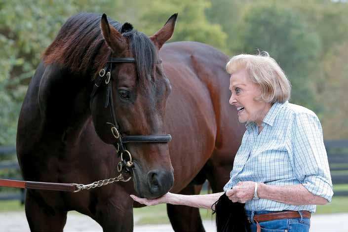 BAbercrombie is a hands-on farm owner. Here she gives a treat to her homebred stallion Alternation.