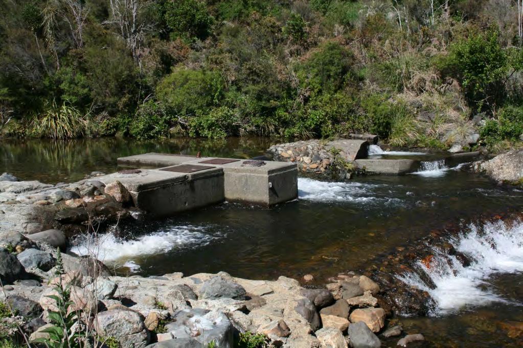 The back feed pipe is permanently fixed into a concrete / rock wall at a height of at least 300 mm above the water level downstream of the weir, with the actual height varying depending on the water