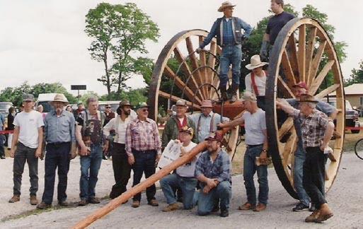 Manistee Muzzle Loading Club members standing in front of the Overpack wheels built by the club and donated to the Manistee County Historical Museum.