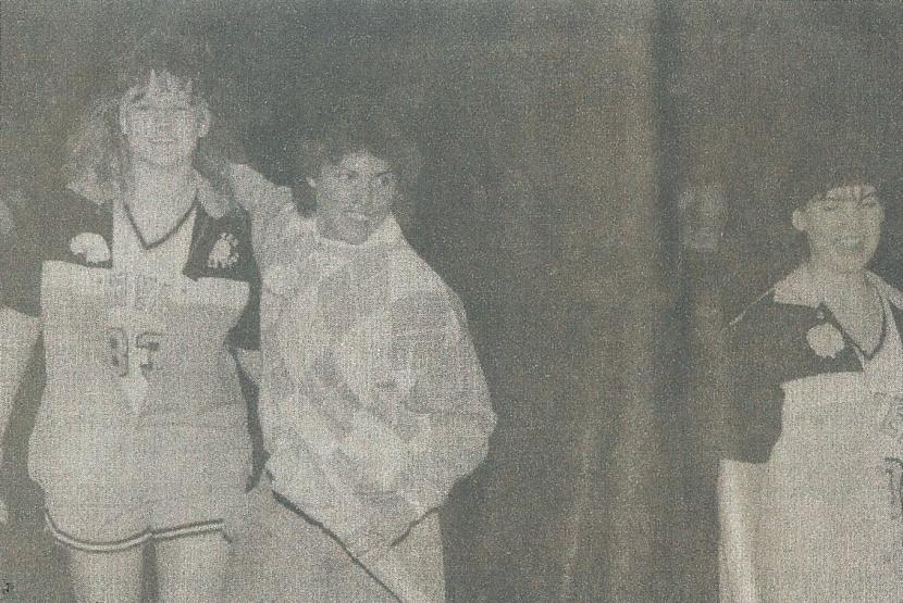 Coach Shelly Pfeil (center), receives flowers and recognition from players Jodi Elmendorf (left) and little sis, Barbara, (right) at last 1989 SHS varsity basketball home game.