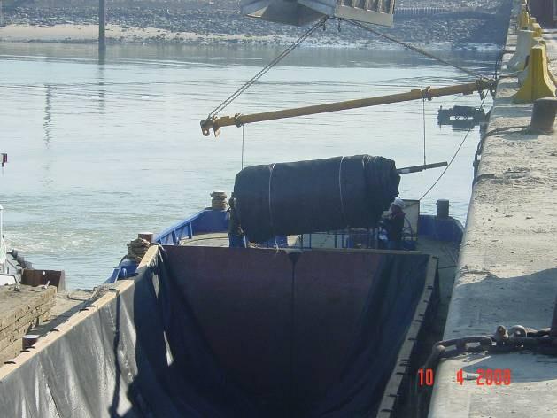 A geocontainer consists of a geotextile which is unrolled with care in a split barge. Then the split barge is filled with sand and the geotextile is sewed up and reinforced with rope ties.