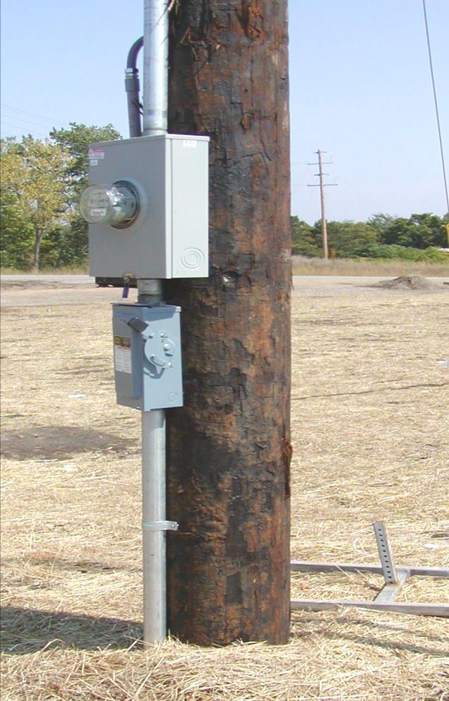 It should be placed so that the conduit and handholes can be easily installed from the pole to the traffic control signal cabinet.
