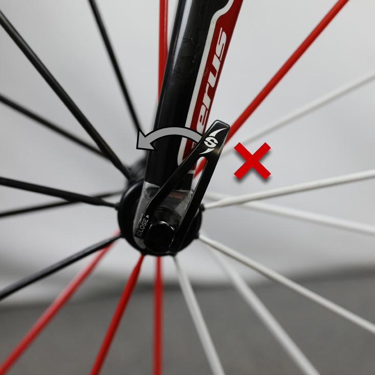 Lift the bicycle and sharply hit the top of the tire (Figure 6). The wheel must not come off.