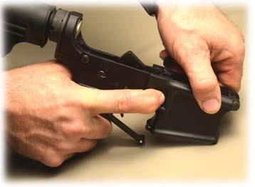 punch, or similar tool will work). 4) Allow the Trigger Guard to pivot down (Photo B) on its rear fixed pin.