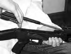 8. Remove the gas tube assembly and upper handguard from the rifle by holding the forward portion of the receiver with your left hand and rotating the gas tube lock arm upward until the flat face of