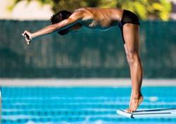 Straighten your body, extend both legs and point your toes immediately upon leaving the board. Enter the water in a vertical, streamlined position.