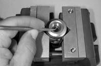 Apply a spanner wrench to one of the larger bore holds of the piston cap(25), and hold it securely seated to turn the cap counter-clockwise to loosen it from the first stage body. (See Fig. 8.