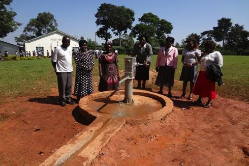 Members of the water committee gather for a picture with the improved water point that