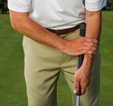 The player holds a longer putter with his hands down the club and with part of the club against his forearm (left).
