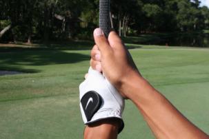 * Place the club diagonally in front of you, across your body. Grip the club in your fingers, making sure the back of your left hand matches the clubface.