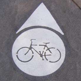 by bicycle. The sign on the right indicates direction and distance.