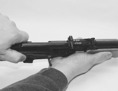 Hold the pistol by the forward portion of the receiver with your hand and with your other hand insert the front edge of the receiver cover into the groove in the back of the gas tube block.