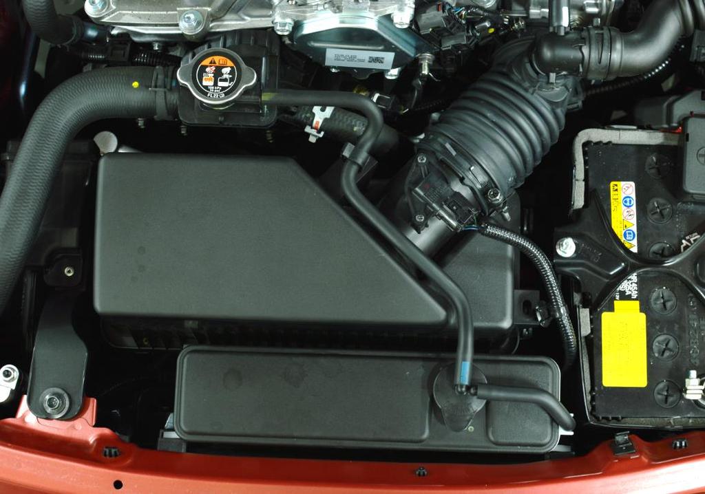Figure 1a a) Remove the coolant reservoir. Open the clip circled in red then remove the overflow hose shown with the red arrow.