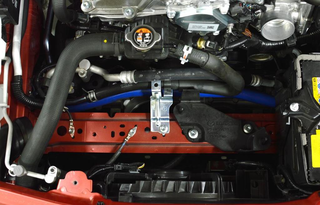 Figure 4a a) Figure 4a shows the engine bay without the coolant reservoir or intake system installed.