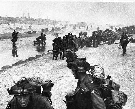 Invasion: Allied forces scramble across the shore at Sword Beach after the Nazis were battered with an aerial attack 'At times like this we were expected to take a nap to use less oxygen.