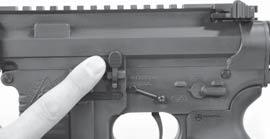 LOADING THE RIFLE 1. Press the bottom of the bolt catch in while pulling all the way back on the charging handle.