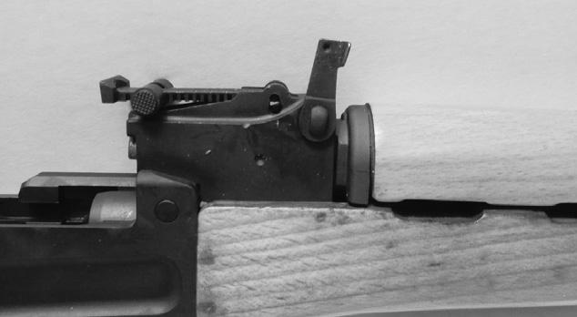 Remove the gas tube assembly and upper handguard from the rifle by holding the forward portion of the receiver with one hand and rotating the gas tube lock arm upward until the flat face of the gas
