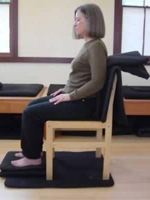 Here the practitioner sits in a chair that is cushioned in the back in order to provide support.