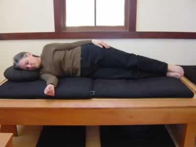 A second option for lying down is the parinirvana posture. Here the practitioner lies on her side (either side) with a zafu or pillow under her head.